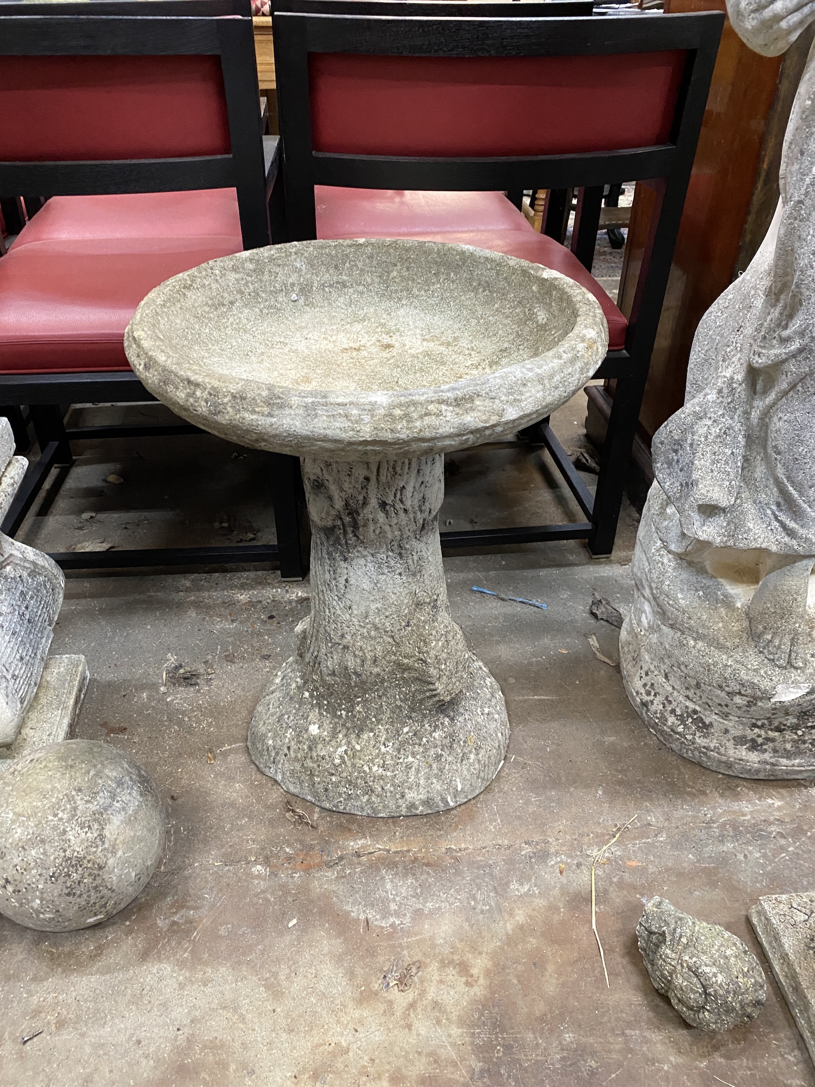 A circular reconstituted stone bird bath, on simulated trunk base, diameter 47cm, height 61cm